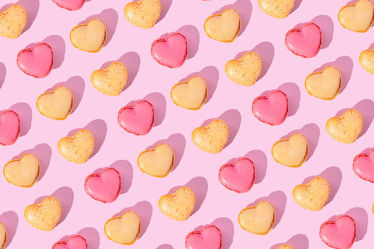 Heart shaped macarons arranged in a pink pattern background