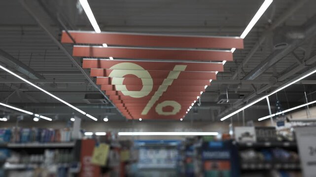 Percentage symbol sign hanging from ceiling of supermarket retail store, indicating discount promotion. Special offer, Markdown concept