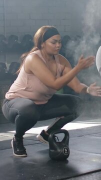 Vertical video: Clapping woman pink-tank rubbing chalk grip gripping kettlebell-5 in gym for lift