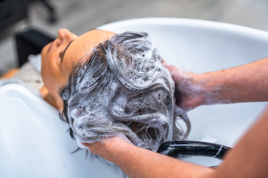 Woman getting hair washed in a salon sink