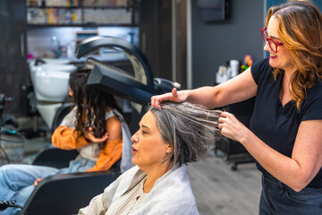 Senior woman receiving hair treatment at salon