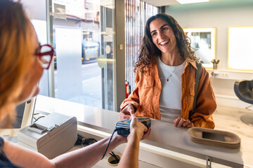 Woman making contactless payment in hair salon