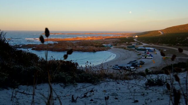 Low dune POV over Tietiesbaai campsite of moonset at sunrise on Cape West Coast