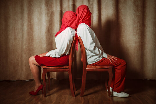 Couple sitting back to back with covered faces expressing dramatic love