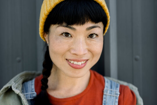 Portrait of smiling woman in urban setting wearing casual jeans outfit