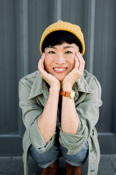 Laughing woman with beanie and casual outfit in urban setting