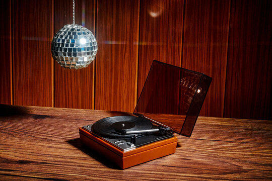Retro turntable and hanging disco ball in intimate analog music setting