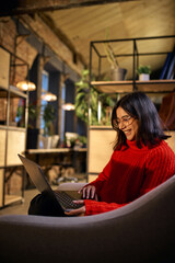 Young woman working on laptop in modern coworking space. Concept of remote work, flexible...