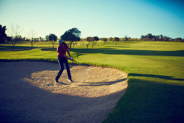 Golf club, training or person in bunker with shot, fitness hobby or performance on weekend break. Sport, man or athlete in sand with swing, outdoor activity or practice session on Sunday afternoon. © JamDay/peopleimages.com