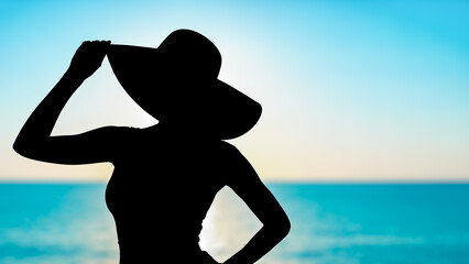 Fototapeta premium Silhouette woman wearing big hat blue sea background summer vacation beach relax travel holiday lifestyle fashion mysterious lady posing ocean view tropical resort calm joy