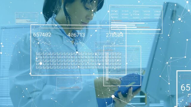 Lab technician holding binder and viewing floating digital panels while recording updated metrics