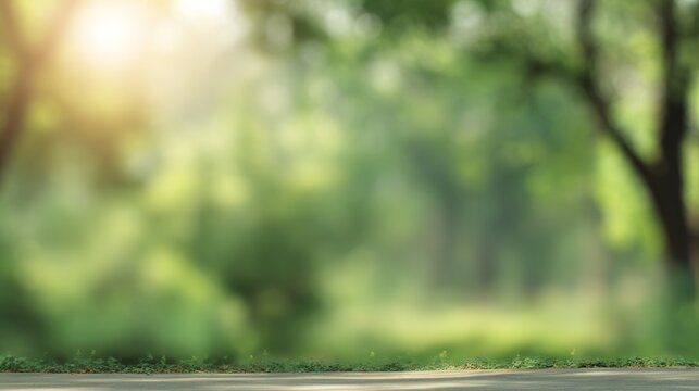 Abstract blurred green nature background with soft bokeh light, defocused trees in summer park, natural sunlight rays, spring freshness, copy space backdrop for wallpaper and web design