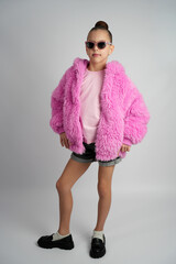 Stylish Young Girl in Bright Pink Faux Fur Jacket and Sunglasses