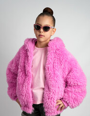 Stylish Young Girl in Bright Pink Faux Fur Jacket and Sunglasses
