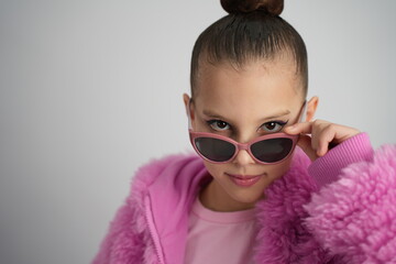 Stylish Young Girl in Bright Pink Faux Fur Jacket and Sunglasses