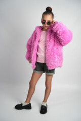 Stylish Young Girl in Bright Pink Faux Fur Jacket and Sunglasses