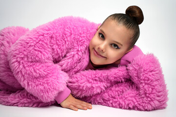 Young Girl in Pink Faux Fur Coat Lying Down and Smiling