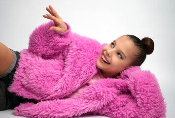 Young Girl in Pink Faux Fur Coat Lying Down and Smiling