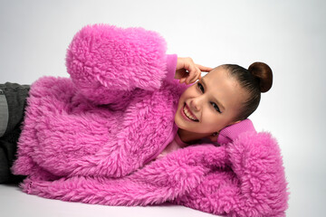Young Girl in Pink Faux Fur Coat Lying Down and Smiling