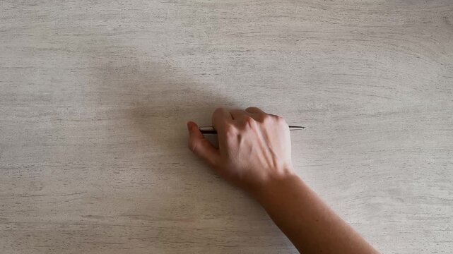 Hand Tapping Fingers on Desk Holding Pen Stress and Waiting