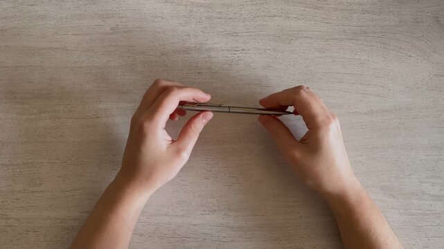 Two Hands Twirling Metal Pen on Desk Idle Fidget Close Up