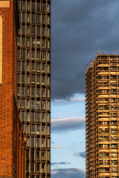 Dramatic evening sky in Berlin behind urban towers and highrise construction with scaffolding shaping modern architecture silhouette