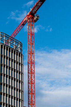 Blue Berlin sky above curved modern office architecture as construction crane towers over urban district for new corporate building