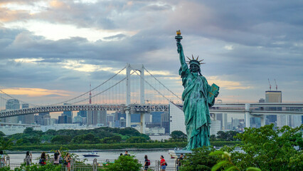 Fototapeta premium Statue of Liberty at Odaiba Tokyo Dusk with Rainbow Bridge