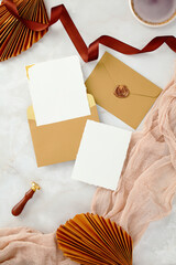 Vertical flat lay of wedding invitation suite with elegant, romantic details.