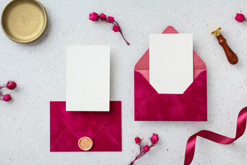 Elegant flat lay with magenta envelopes, a blank card, and wax seal details