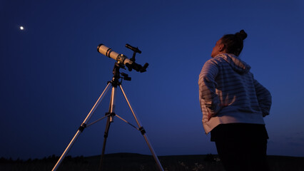 Fototapeta premium Amateur astronomer using telescope for watching stars, Moon, planets and other celestial objects from a field in nature.