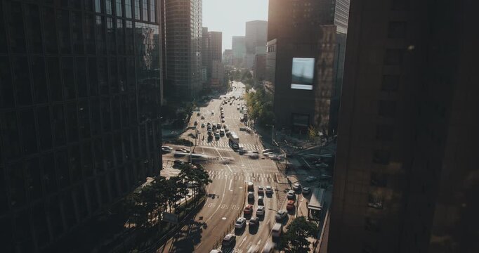Aerial view of bustling city traffic as vehicles navigate intersections, surrounded by modern architecture and vibrant urban environment. Time-lapse, Seoul, South Korea