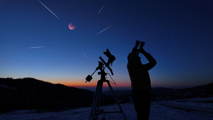 Fototapeta premium Amateur astronomer observing stars, planets, Moon eclipse and other celestial objects.