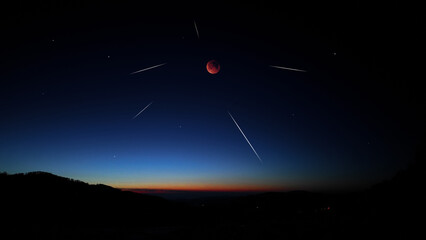 Fototapeta premium Blue hour time with lunar eclipse, stars and planets above landscape silhouettes.