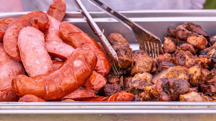 Grilled sausages and roasted meat in server