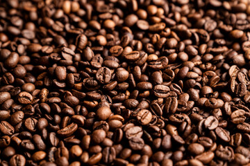 Fototapeta premium Freshly roasted coffee beans in a close view of a large pile