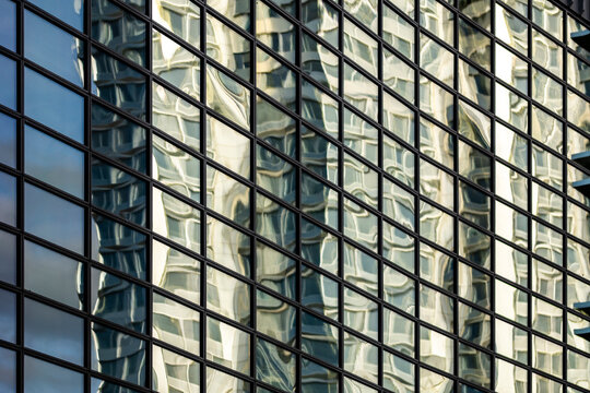 Modern urban glass facade windows grid reflection with abstract geometry pattern on curved skyscraper surface for technology and architecture background