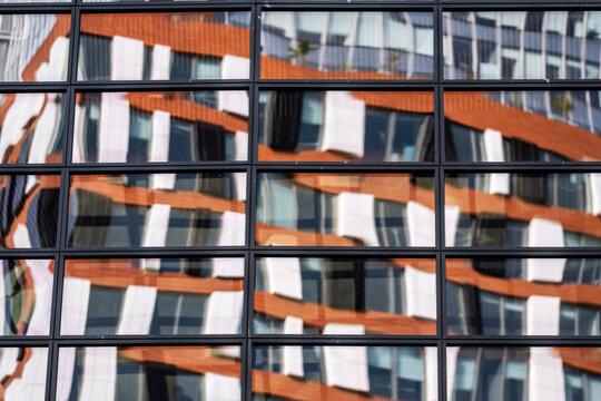 Modern urban glass facade windows reflection with distortion and color creating abstract pattern for creative architecture background and design concept