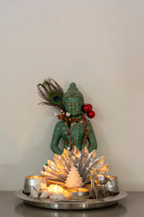 Small Buddha staue with candles and silver ornamentd