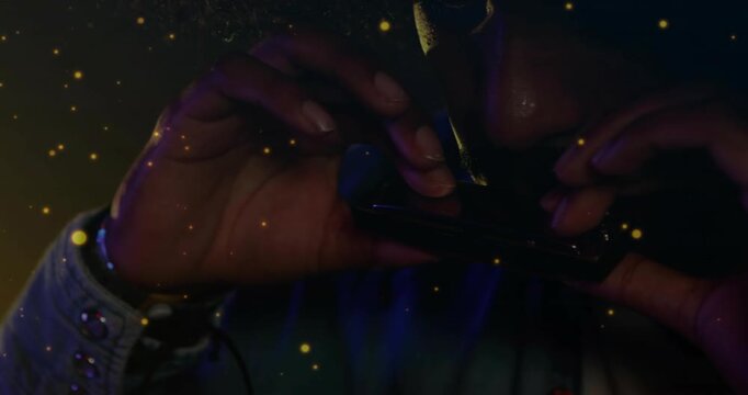 Man holding harmonica at mouth and playing for music while cigarette resting and particles drifting