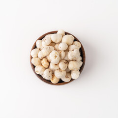Phool Makhana, Fox Nut, Lotus Pops Seeds, Gorgon nut, Euryale Ferox on a wooden bowl with white background.
