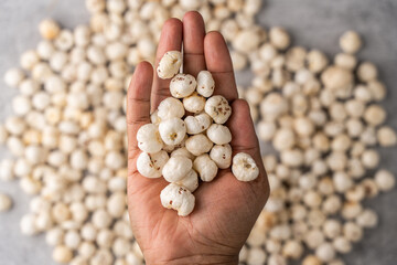 Phool Makhana, Fox Nut, Lotus Pops Seeds, Gorgon nut, Euryale Ferox on a human hand.