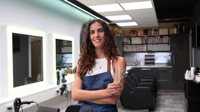 Professional hairdresser smiling holding scissors and comb