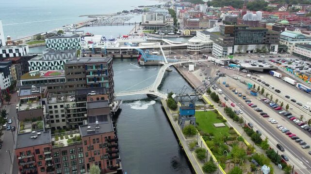 Cars leaving ferry at Helsingborg harbor under overcast sky, urban landscape