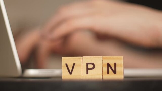 VPN concept for secure internet access: &ldquo;VPN&rdquo; word made of letters with a working laptop in the background
