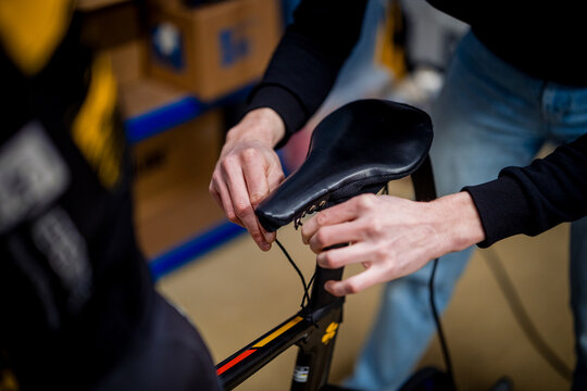 Mechanic adjusting racing bike saddle for optimal performance