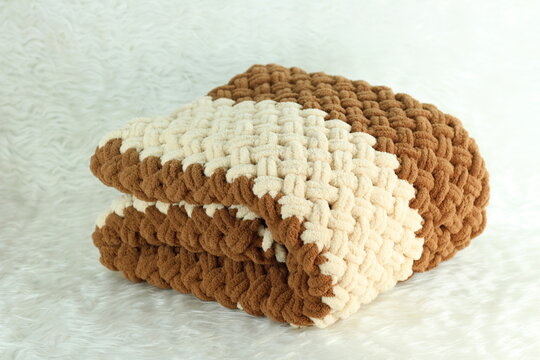 Handmade beige and brown puffy blanket with large loops on furry white blanket.