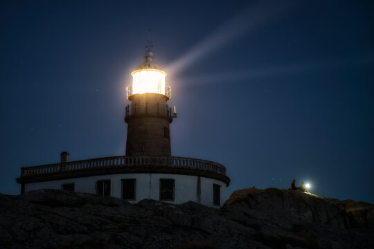 Turistas con linterna en el Faro de Corrubedo durante la noche. Galicia, Espa&ntilde;a.