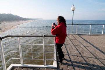 kobieta z aparatem na molo © marsad