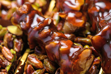 Detailed close-up of a traditional Turkish walnut sausage sucuk with honey glaze and nut pieces.